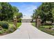 Long concrete driveway leading to a detached three-car garage with an iron gate at 1253 Culbreath Rd, Brooksville, FL 34602