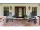 Inviting front porch with brick flooring, rocking chairs, and decorative plants offers a relaxing outdoor space at 1253 Culbreath Rd, Brooksville, FL 34602