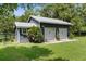 Two car garage with metal roof with manicured lawn and landscaping at 1253 Culbreath Rd, Brooksville, FL 34602