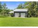 A two-car garage with a metal roof and a large well-maintained lawn at 1253 Culbreath Rd, Brooksville, FL 34602