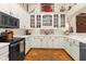 Bright kitchen with white cabinets, modern appliances, and glass shelving provides ample storage and workspace at 1253 Culbreath Rd, Brooksville, FL 34602