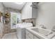 Bright laundry room features tile floors, utility sink, washer, dryer, and ample storage at 1253 Culbreath Rd, Brooksville, FL 34602