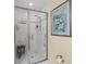 Frameless shower features a built-in bench and niche for toiletries, complemented by tasteful artwork at 1253 Culbreath Rd, Brooksville, FL 34602