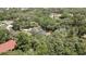 A bird's-eye view of a quaint home, featuring a private screened pool and surrounded by dense trees at 12722 Oak Tree Dr, Hudson, FL 34667