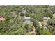 Overhead view of a cozy home, enveloped by a canopy of trees, with a screened pool in the backyard at 12722 Oak Tree Dr, Hudson, FL 34667