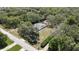 Expansive aerial view of a secluded single-story home featuring a screened-in pool and lush landscaping at 12722 Oak Tree Dr, Hudson, FL 34667