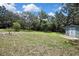 Expansive backyard featuring mature trees and a storage shed, offering a private retreat at 12722 Oak Tree Dr, Hudson, FL 34667