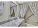 Bathroom sink and tub with patterned curtain, offering a well-lit and clean space at 12722 Oak Tree Dr, Hudson, FL 34667