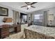 Comfortable bedroom with a ceiling fan, desk, TV, and window with curtains for natural light at 12722 Oak Tree Dr, Hudson, FL 34667