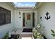 Inviting front door entrance with decorative wreath and well-maintained tiled entryway, enhanced by lush plants and greenery at 12722 Oak Tree Dr, Hudson, FL 34667