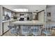 Kitchen featuring a breakfast bar with seating, stainless steel refrigerator, and light wood cabinetry at 12722 Oak Tree Dr, Hudson, FL 34667