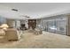 Cozy living room featuring a stone fireplace and sliding glass doors to a screened-in pool area at 12722 Oak Tree Dr, Hudson, FL 34667