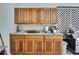 Functional outdoor kitchen featuring wooden cabinets, a countertop, and a grill at 12722 Oak Tree Dr, Hudson, FL 34667