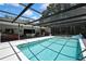 A partially covered and screened in pool is adjacent to a lounge area for easy entertaining at 12722 Oak Tree Dr, Hudson, FL 34667