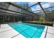 Inviting screened-in pool with sunny deck and lush surroundings offer ideal outdoor living at 12722 Oak Tree Dr, Hudson, FL 34667