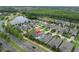 Aerial view of home with neighborhood and a lake and wooded area in the background at 12854 Rangeland Blvd, Odessa, FL 33556