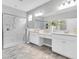 Modern bathroom featuring a walk-in shower, double sinks and light gray tile flooring at 12854 Rangeland Blvd, Odessa, FL 33556