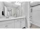 Bright bathroom featuring white cabinetry, a large mirror, and a doorway leading to the tub/shower combo at 12854 Rangeland Blvd, Odessa, FL 33556