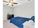 Cozy bedroom featuring a ceiling fan, a comfortable blue bed, and a dresser for storage and personal items at 12854 Rangeland Blvd, Odessa, FL 33556
