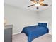 Relaxing bedroom with a ceiling fan, a comfortable blue bed, and a dresser for clothes and personal items at 12854 Rangeland Blvd, Odessa, FL 33556