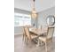Light-filled dining area featuring a modern chandelier and a wood dining table at 12854 Rangeland Blvd, Odessa, FL 33556