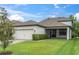 Charming one-story home with a manicured lawn, a paver driveway and a two car garage at 12854 Rangeland Blvd, Odessa, FL 33556