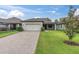 Charming one-story home with a manicured lawn, a paver driveway and a two car garage at 12854 Rangeland Blvd, Odessa, FL 33556