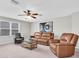Inviting living room with a ceiling fan, natural light from a window, and comfortable seating for relaxation at 12854 Rangeland Blvd, Odessa, FL 33556