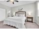 Spacious main bedroom featuring a ceiling fan, large bed, and a doorway leading to the en-suite bathroom at 12854 Rangeland Blvd, Odessa, FL 33556