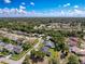Wide aerial shot of a residential neighborhood featuring tidy homes amidst lush greenery under a beautiful blue sky with clouds at 13627 Glaze Brook Dr, Hudson, FL 34667