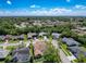 An aerial view displaying a neighborhood with tree-lined streets and houses surrounded by lush vegetation at 13627 Glaze Brook Dr, Hudson, FL 34667