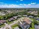 Expansive aerial view of the neighborhood showcasing the home with lush landscaping and beautiful blue skies above at 13627 Glaze Brook Dr, Hudson, FL 34667