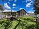 Backyard view showing the house and screened-in patio area at 13627 Glaze Brook Dr, Hudson, FL 34667