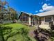 Well-manicured backyard featuring a screened-in lanai, lush green grass, and a charming white picket fence at 13627 Glaze Brook Dr, Hudson, FL 34667