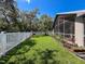 Spacious backyard featuring lush green grass, landscaping, and a white picket fence at 13627 Glaze Brook Dr, Hudson, FL 34667