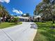 Beautiful home with mature trees and tropical landscaping lining the circular driveway at 13627 Glaze Brook Dr, Hudson, FL 34667