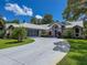 Charming single-Gathering home features a welcoming front yard, a screened garage, and a curved driveway at 13627 Glaze Brook Dr, Hudson, FL 34667