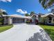 Charming single-Gathering home features a welcoming front yard, a screened garage, and a curved driveway at 13627 Glaze Brook Dr, Hudson, FL 34667