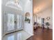 Bright foyer with double entry doors and transom window leading to a sitting area with hardwood floors at 13627 Glaze Brook Dr, Hudson, FL 34667
