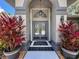 Elegant entryway with double doors, decorative plants, and black and white tile flooring at 13627 Glaze Brook Dr, Hudson, FL 34667
