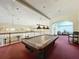 Spacious game room featuring a billiard table under elegant lighting, with a balcony view at 13627 Glaze Brook Dr, Hudson, FL 34667