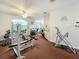 Community gym with weightlifting and cardio machines, with windows overlooking the landscaped exterior at 13627 Glaze Brook Dr, Hudson, FL 34667