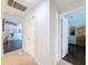 Bright hallway showcasing tile flooring and white doors leading to various rooms in the home at 13627 Glaze Brook Dr, Hudson, FL 34667