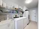 Functional laundry room features a washer, dryer, utility sink, and ample shelving for storage solutions at 13627 Glaze Brook Dr, Hudson, FL 34667