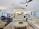 Cozy living room with a vaulted ceiling, ceiling fan, open layout to the kitchen, and stylish modern furniture at 13627 Glaze Brook Dr, Hudson, FL 34667