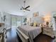Spacious main bedroom featuring a ceiling fan, ensuite, wood floors, and neutral colors at 13627 Glaze Brook Dr, Hudson, FL 34667