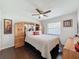 Cozy main bedroom featuring a decorative headboard, ceiling fan and natural light from the window at 13627 Glaze Brook Dr, Hudson, FL 34667