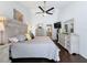 Spacious main bedroom featuring a ceiling fan, ensuite, wood floors, and neutral colors at 13627 Glaze Brook Dr, Hudson, FL 34667