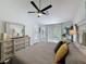 Spacious main bedroom featuring a ceiling fan, ensuite, wood floors, and neutral colors at 13627 Glaze Brook Dr, Hudson, FL 34667