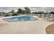 An inviting community pool surrounded by lounge seating and shade with secure fencing at 13627 Glaze Brook Dr, Hudson, FL 34667